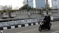 Pengendara motor melintasi jembatan layang Jalan HR Rasuna Said, Jakarta, Selasa (11/7). Dinding pembatas jembatan layang HR Rasuna Said arah kuningan dipenuhi coretan. (Liputan6.com/Helmi Fithriansyah)