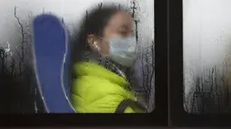 Seorang penumpang memakai masker di dalam bus, Beijing, Cina, (13/11). Pemerintah Cina mengumumkan bahwa kualitas udara mengalami penurunan akibat tercemar polusi. (REUTERS/Jason Lee)