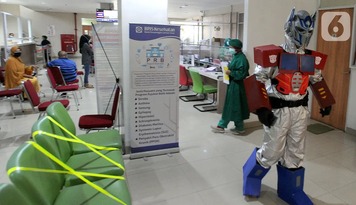 Dokter Rollando Erric Manibuy SpOT mengenakan alat pelindung diri (APD) ala transformer saat berada di RS Vania, Bogor, Jawa Barat, Jumat (22/5/2020). Penggunaan APD unik sejak merebaknya COVID-19 tersebut agar pasien tetap optimis meski sedang dalam pandemi. (merdeka.com/Arie Basuki)