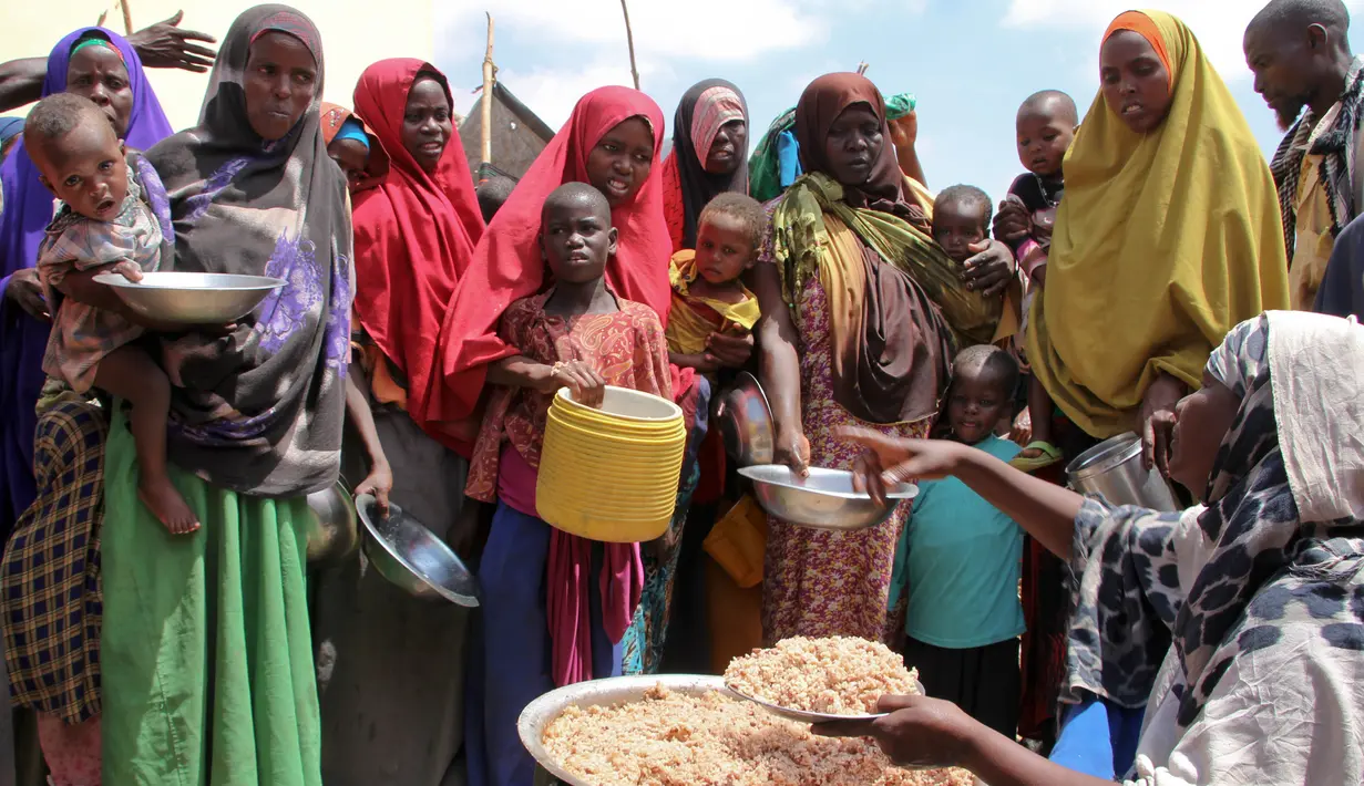 Warga Somalia mengantre untuk mendapat makanan di kamp pengungsian sementara di daerah Tabelaha di pinggiran Mogadishu, Somalia (30/3). Kekeringan ini mengancam setengah dari penduduk negara Somalia. (AP Photo/Farah Abdi Warsameh)