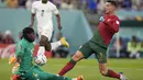 Kiper Ghana Lawrence Ati-Zigi melakukan penyelamatan dari tembakan penyerang Portugal Cristiano Ronaldo pada duel grup H Piala Dunia 2022 di stadion 974, Kamis (24/11/2022). Ronaldo kini menjadi pemain pertama dalam sejarah yang mencetak gol di lima Piala Dunia.  (AP Photo/Darko Bandic)