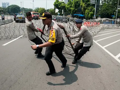 Polisi memasang kawat berduri saat peringatan May Day di depan Istana Negara, Jakarta, Senin (1/5). Kawat berduri dipasang untuk mengantisipasi puluhan ribu buruh yang akan menggelar aksi unjuk rasa di Istana Negara. (Liputan6.com/Gempur M Surya)