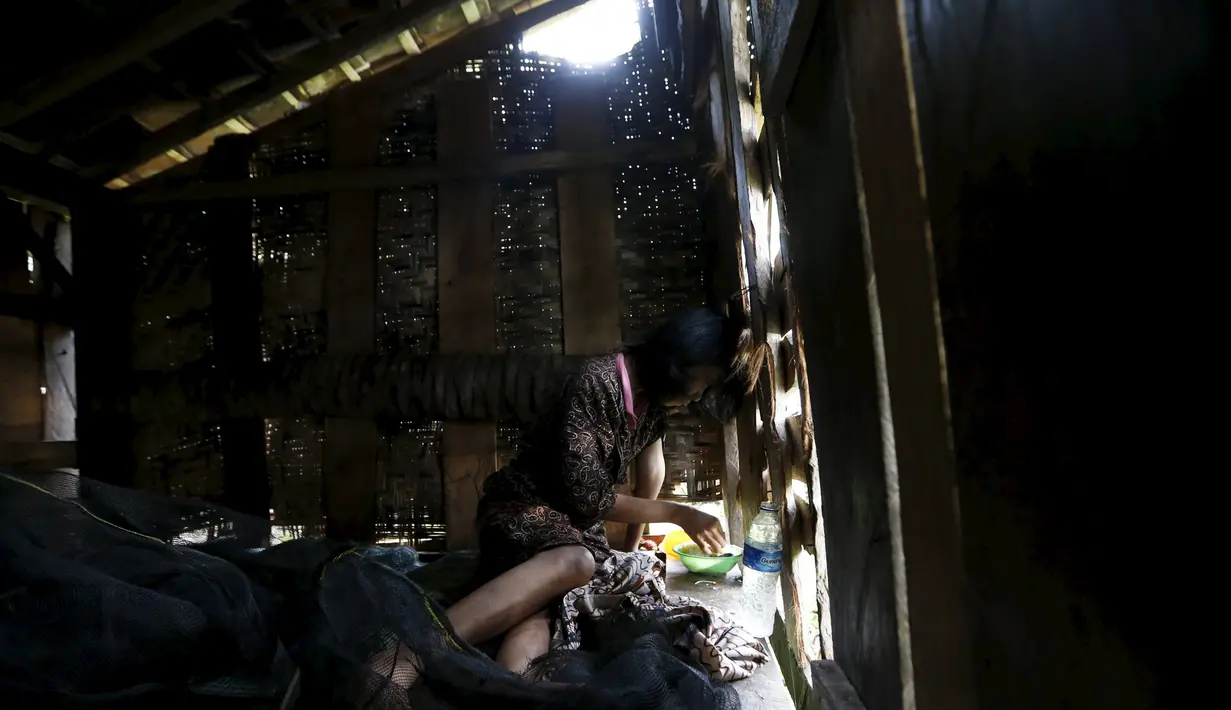 Seorang wanita bernama Jumia makan siang sambil dipasung di desa Jambu, Serang, Banten, Indonesia (23/3). Tahun ini Indonesia mengirimkan tim medis untuk membantu pasien yang mengalami ganguan mental. (REUTERS/Beawiharta)
