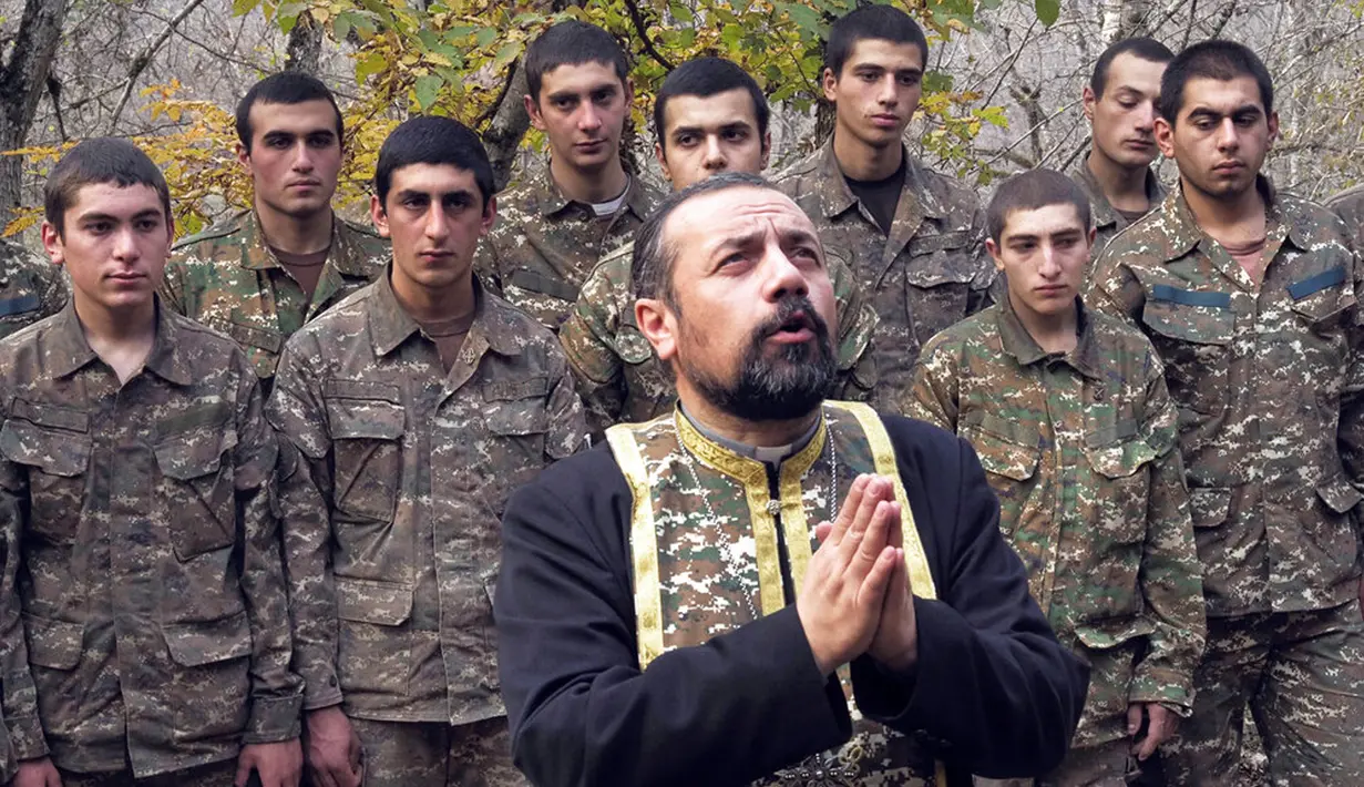 Pendeta Sebeos Galachyan membaptis tentara etnis Armenia di sebuah kamp militer dekat garis depan konflik di wilayah separatis Nagorno-Karabakh, Azerbaijan, Senin (2/11/2020). Pasukan Armenia dan Azerbaijan saling menyalahkan atas serangan baru selama perebutan Nagorno-Karabakh. (AP Photo)