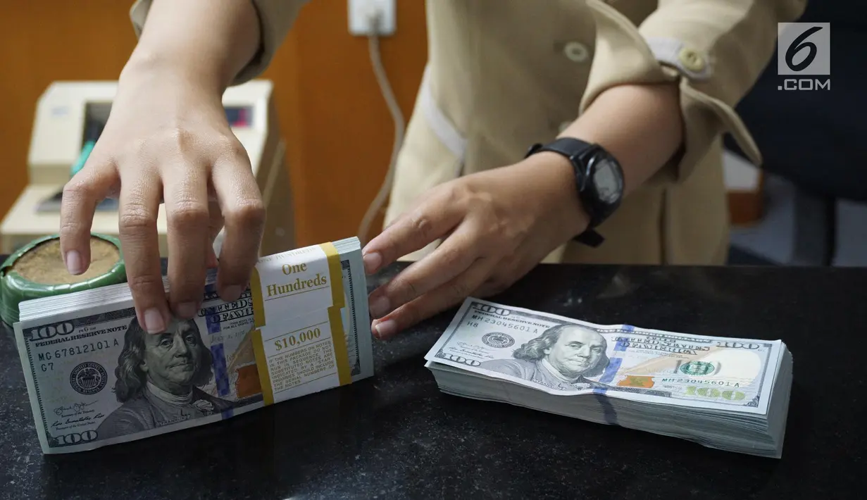Teller menunjukkan mata uang dolar AS di penukaran uang di Jakarta, Rabu (10/7/2019). Nilai tukar rupiah terhadap dolar Amerika Serikat (AS) ditutup stagnan di perdagangan pasar spot hari ini di angka Rp 14.125. (Liputan6.com/Angga Yuniar)