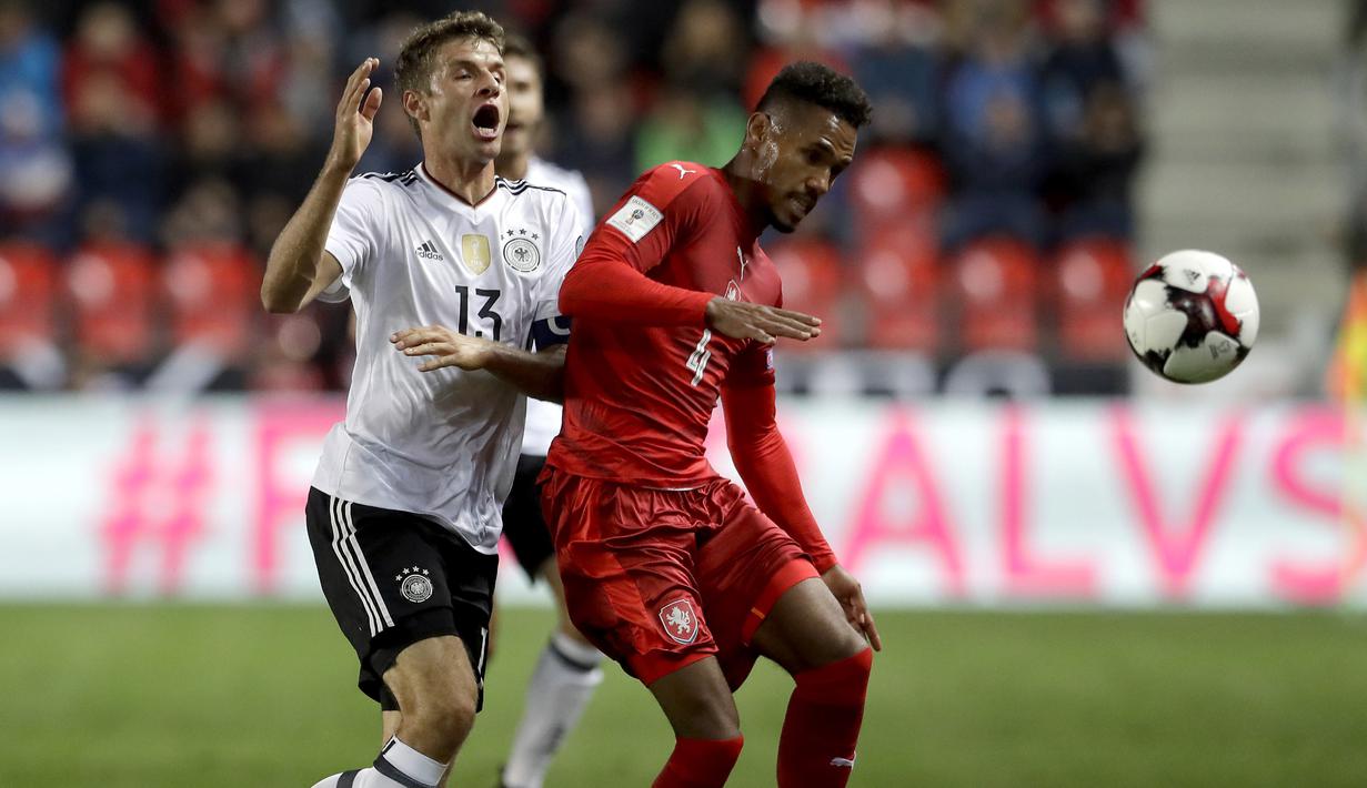 Pemain Jerman, Thomas Müller (kiri) berebut bola dengan pemain Republik Ceska, Theodor Gebre Selassie  pada laga Grup C kualifikasi Piala Dunia 2018 di Plzen, Republik Ceska (1/9/2017). Jerman menang 2-1. (AP/Petr David Josek)
