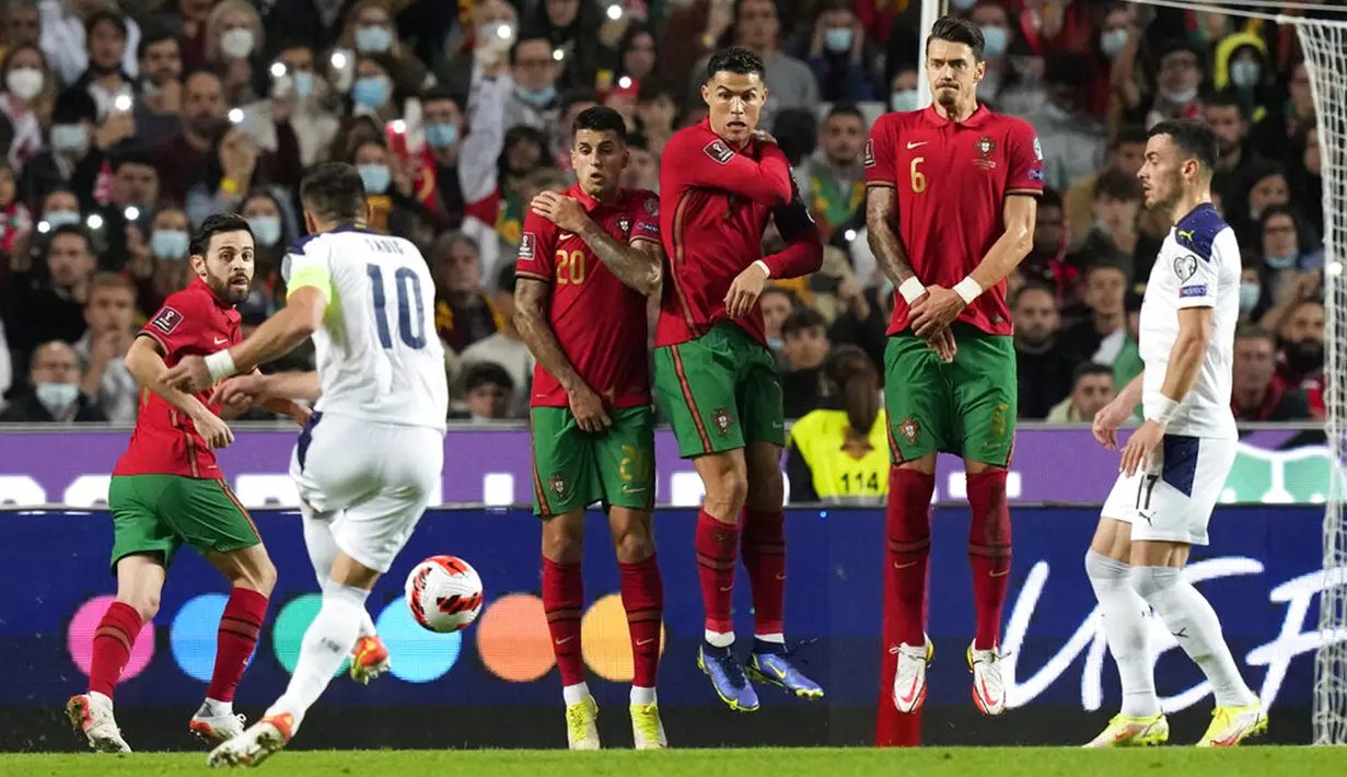 Tembok pertahanan Portugal menghalangi tendangan bebas pemain Serbia Dusan Tadic pada pertandingan kualifikasi Grup A Piala Dunia 2022 di Stadion Luz, Lisbon, 14 November 2021. Serbia menang 2-1. (AP Photo/Armando Franca)