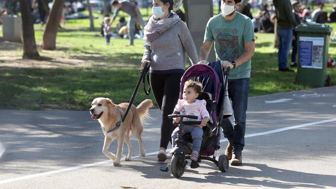 Sebua keluarga dengan membawa anjingnya berjalan santai di Tel Aviv, Israel, pada 26 Desember 2020. Kementerian Kesehatan Israel melaporkan 3.624 kasus baru COVID-19, sehingga totalnya bertambah menjadi 398.015 kasus. (Xinhua/JINI/Gideon Markowicz)