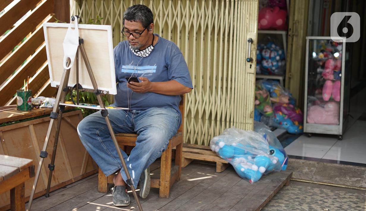 Seorang pria melukis di Gembrong Baru, Jalan Jenderal Basuki Rachmat, Jakarta Timur, Minggu (16/8/2020). Pasar yang dulu diisi kios-kios mainan anak dan boneka tersebut kini berubah wajah menjadi galeri bagi para perupa, barang antik, hingga buku-buku lawas. (Liputan6.com/Immanuel Antonius)