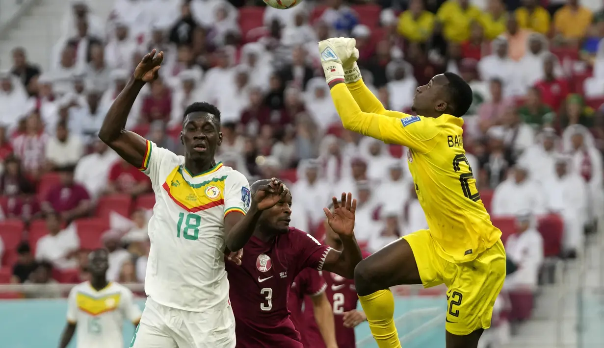 Penjaga gawang Qatar Meshaal Barsham melakukan penyelamatan selama pertandingan grup A Piala Dunia 2022 di Stadion Al Thumama di Doha, Qatar, Jumat (25/11/2022). Senegal menang atas tuan rumah Qatar dengan skor 3-1. (AP Photo/Thanassis Stavrakis)