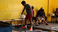 Eko Yuli membersihkan bantalan tempat berlatih dekat halaman Parkir Angkat Besi di Senayan, Jakarta, Senin (11/1/2016).  Hal ini karena tempat Latihan dalam tahap renovasi. (Bola.com/Nicklas Hanoatubun)