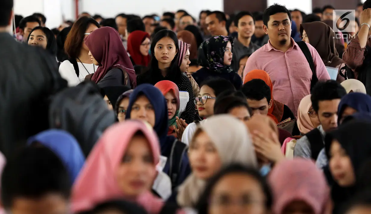 Peserta mengantre untuk pendaftaran ulang ujian CPNS Kementerian Kelautan dan Perikanan (KKP) di Jakarta, Minggu (8/10). Pembukaan lowongan CPNS ini dalam rangka mengisi kekosongan 41 jabatan pada Kantor Pusat dan UPT di KKP. (Liputan6.com/Johan Tallo)