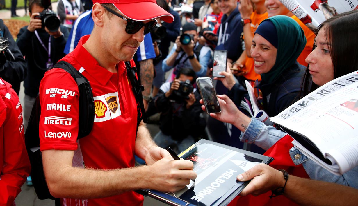 Pembalap Ferrari Sebastian Vettel menandatangani tanda tangan untuk para penggemar saat tiba di Sirkuit Melbourne Grand Prix di Melbourne, Jumat (15/3). GP Australia digelar di Sirkuit Melbourne Grand Prix, 15 hingga 17 Maret. (Reuters/Edgar Su)