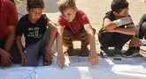 Anak -anak meratapi jenazah korban Palestina yang tewas akibat serangan tentara Israel di pelabuhan Kota Gaza sehari sebelumnya, saat upacara pemakaman di Kota Gaza, Rabu,19 Agustus 2026. (AFP/ Omar Al-Qattaa)
