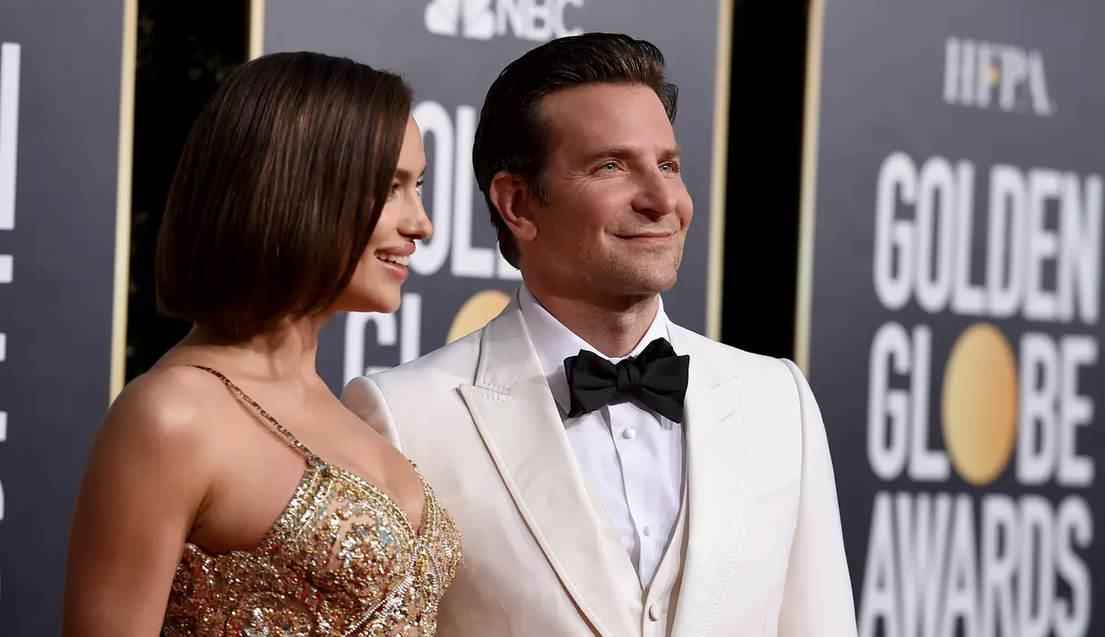 Irina Shayk dan aktor Bradley Cooper berpose saat menghadiri Golden Globe Awards ke-76 di Beverly Hills, California (6/1). Irina tampil mengenakan gaun emas. Sedangkan Bradley Cooper tampil dengan tuksedo putih. (AP Photo/Jordan Strauss)