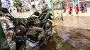 Sebuah motor dilumuri air lumpur terlihat dibiarkan saja oleh pemiliknya di halaman masjid komplek Pondok Gede Permai, Bekasi, Jumat (22/4). Sejak banjir menerjang perumahan tersebut hanya sekitar 50 warga yang mau dievakuasi. (Liputan6.com/Fery Pradolo)