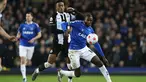 Gelandang Newcastle United Joe Willock berbeut bola dengan gelandang Everton Abdoulaye Doucoure pada lanjutan Liga Inggris di Stadion Goodison Park, Liverpool, Jumat (18/3/2022) dini hari WIB. Bertindak sebagai tuan rumah, Everton menang tipis 1-0.  (Richard Sellers/PA via AP)