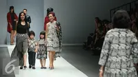 Mantan Gubernur BI, Miranda Goeltom bersama anak dan cucunya membawakan busana rancangan Batik Danar Hadi di Jakarta Fashion Week 2016 di Senayan City, Jakarta, Kamis (29/10/2015). (Liputan6.com/Herman Zakharia)