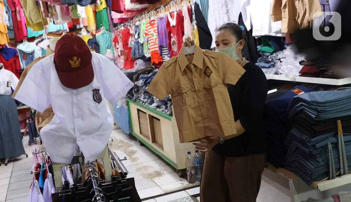 Pedagang merapikan seragam sekolah baru dagangannya di salah satu toko di Tangerang, Banten, Selasa (2/6/2020). Menjelang tahun ajaran baru, sejumlah pedagang di tempat tersebut mengeluh karena omzet penjualan seragam sekolah menurun drastis akibat pandemi COVID-19. (Liputan6.com/Angga Yuniar)