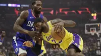 LeBron James (kuning) berduel dengan Kawhi Leonard pada laga hari pertama NBA 2019-2020 (AP)