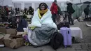 Seorang wanita menutupi dirinya dengan selimut agar tetap hangat setelah melarikan diri dari Ukraina dan tiba di perbatasan di Medyka, Polandia, Senin (7/3/2022). Hampir 2 juta orang melarikan diri dari Ukraina sejak invasi Rusia dengan jumlah itu meningkat setiap hari. (AP Photo/Markus Schreiber)