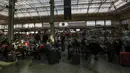 Orang-orang yang memakai masker menunggu dengan barang bawaan mereka di stasiun kereta Gare de Lyon di Paris, Jumat (19/3/2021). Prancis menerapkan karantina wilayah di Paris dan beberapa daerah lain di bagian utara selama sebulan dan dimulai pada Jumat tengah malam. (AP Photo/Michel Euler)