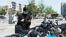 Seorang warga memindai kode respons cepat (QR) pada layanan berbagi sepeda listrik dengan ponsel pintar di Distrik Fancheng di Kota Xiangyang, Provinsi Hubei, China tengah (24/4/2020). (Xinhua/Xie Jianfei)