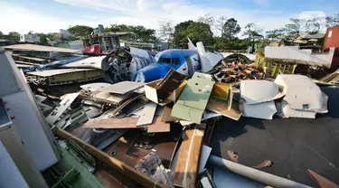 Potongan badan pesawat tertumpuk di lahan kosong kawasan Marunda, Jakarta Utara, Selasa (19/11/2019). Menurut warga sekitar potongan-potongan badan pesawat tersebut sudah ada sejak 3 bulan lalu dan akan dikirim ke China untuk dijadikan bangunan restoran cepat saji. (merdeka.com/Iqbal S. Nugroho)