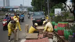 Petugas Bina Marga memerlebar saluran air di Jalan TB Simatupang di kawasan Cilandak, Jakarta, Kamis (22/10/2020). Hal tersebut dilakukan guna memaksimalkan fungsi sistem drainase agar tidak terjadi genangan air saat menghadapi musim hujan. (Liputan6.com/Immanuel Antonius)