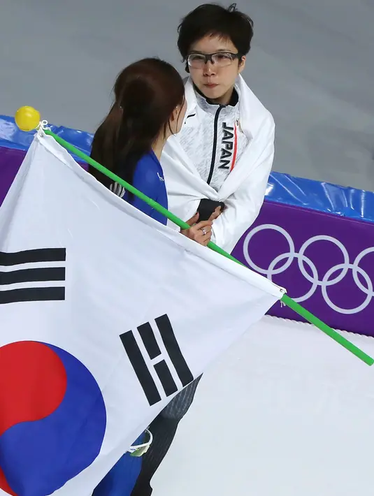Peraih medali emas, skater Nao Jepang Kodaira memeluk dan memberikan dukungan kepada skater Korsel Lee Sang Hwa yang menangis tersedu karena hanya mendapatkan medali perak di Olimpiade Musim Dingin Pyeongchang 2018, Minggu (18/2). (AP/Eugene Hoshiko)