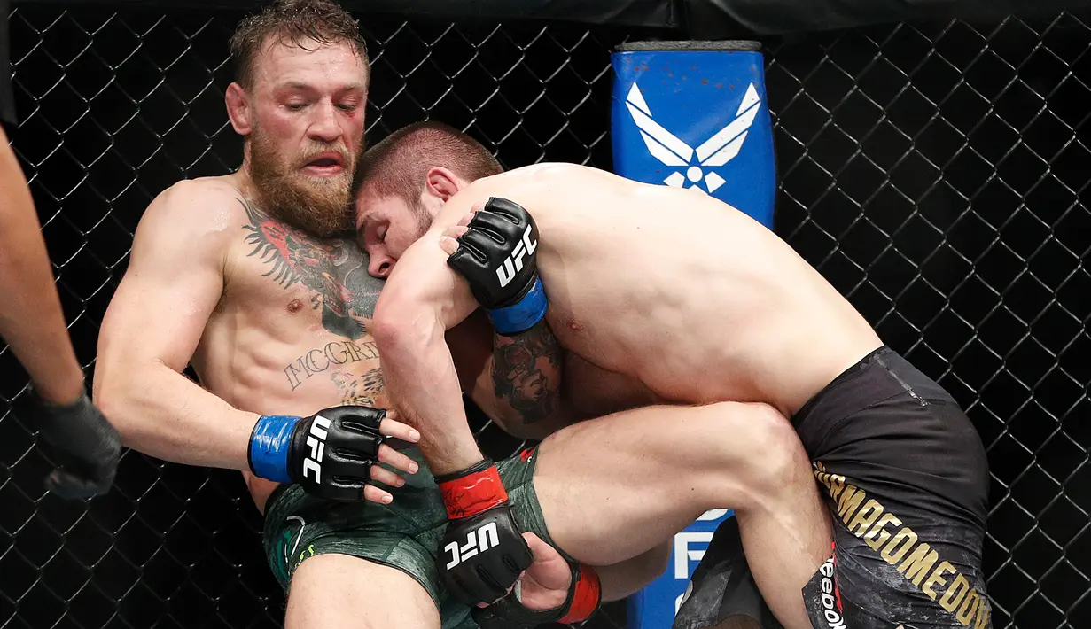 Khabib Nurmagomedov saat mengunci Conor McGregor dalam pertarungan UFC 229 di Las Vegas, AS (6/10). Nurmagomedov dinyatakan menang melalui submission. Dia melakukan rear naked choke kepada McGregor. (AP Photo/John Locher)