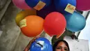 Seorang mahasiswa pengunjuk rasa memegang balon selama demonstrasi menentang pembelian kapal selam oleh pemerintah yang berpihak pada militer di Bangkok (31/8/2020). (AFP/Lillian Suwanrumpha)