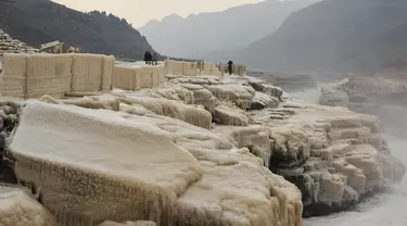 Wisatawan menikmati pemandangan musim dingin objek wisata Air Terjun Hukou di wilayah Jixian, Provinsi Shanxi, China utara, pada 9 Desember 2020. Air terjun Hukou terletak di daerah perbatasan antara Provinsi Shanxi di China utara dan Provinsi Shaanxi di China barat laut. (Xinhua/Lyu Guiming)