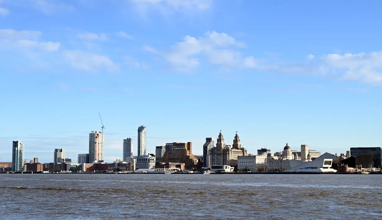 File foto 13 Oktober 2020, bangunan di tepi pantai Liverpool termasuk Liver Building terlihat di seberang Sungai Mersey. Kota Liverpool telah dihapus dari daftar situs warisan dunia UNESCO pada 21 Juli 2021 karena hadirnya bangunan baru yang merusak daya tarik dermaga Victoria. (Paul ELLIS/AFP)