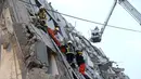 Tim penyelamat mengevakuasi warga yang berada dibangunan yang runtuh akibat 6,4 SR mengguncang Tainan di Taiwan, Sabtu (6/2). Gempa terjadi pukul 4 subuh tadi telah menghancurkan beberapa apartemen di kawasan Wei Guan, Tainan, Taiwan. (REUTERS/Stringer)