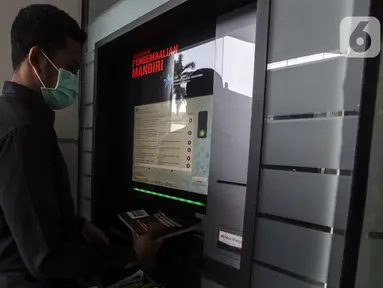 Pegawai memasukkan buku ke dalam mesin book drop di Perpustakaan Nasional, Jakarta. Kamis (18/3/2021). Perpustakaan Nasional menyediakan layanan pengembalian buku mandiri untuk pengunjung melalui mesin book drop. (Liputan6.com/Johan Tallo)