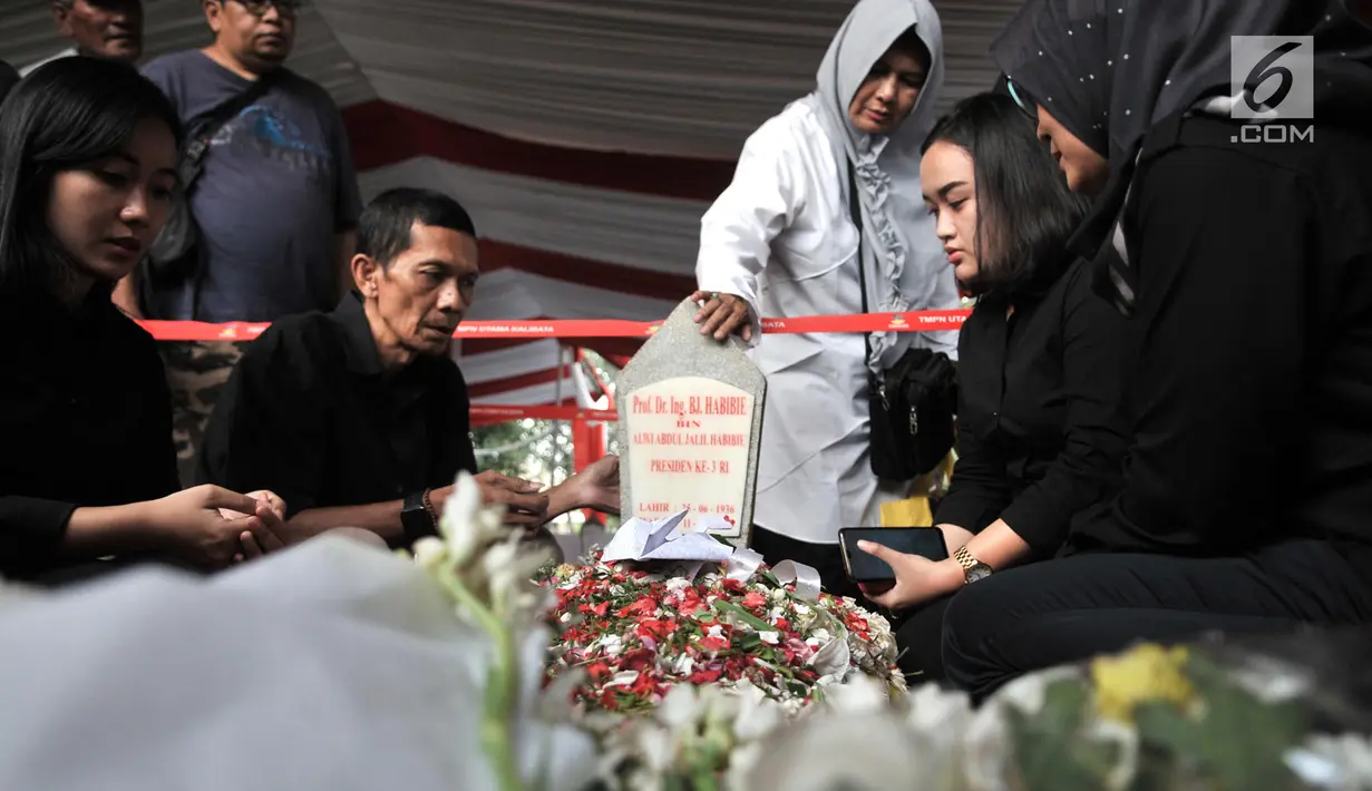 Warga membaca doa di depan makam Presiden ketiga RI BJ Habibie di TMP Kalibata, Jakarta, Kamis (12/9/2019). Tidak hanya dihadiri tokoh-tokoh penting, ratusan warga juga antusias datang ke TMP Kalibata untuk mengantarkan BJ Habibie ke tempat peristirahatan terakhirnya. (merdeka.com/Iqbal Nugroho)