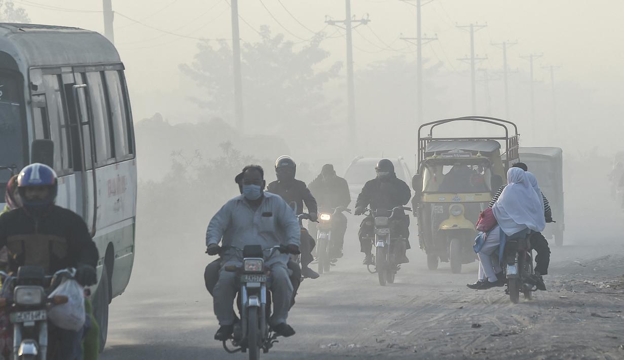 Pengendara melintas di sepanjang jalan di tengah kondisi kabut asap di Lahore, Pakistan (23/11/2021). Kondisi kabut asap yang memburuk membuat Lembaga pendidikan, kantor swasta tutup selama tiga hari seminggu di Lahore. (AFP/Arif Ali)