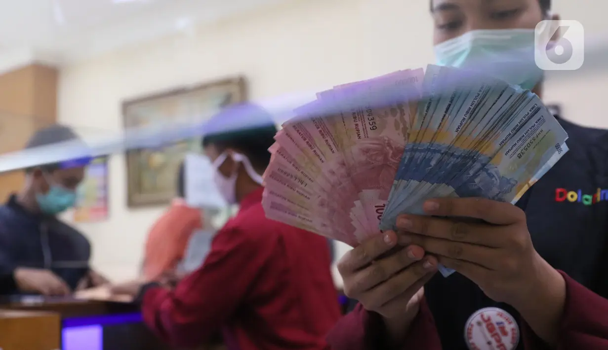Petugas menunjukkan mata uang rupiah di penukaran uang di Jakarta, Senin (9/11/2020). Rupiah dibuka di angka 14.172 per dolar AS, menguat jika dibandingkan dengan penutupan perdagangan sebelumnya yang ada di angka 14.210 per dolar AS. (Liputan6.com/Angga Yuniar)