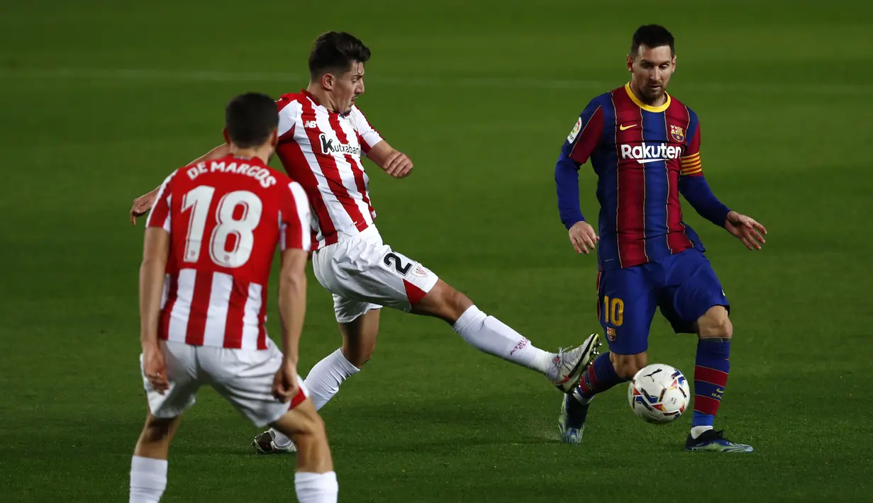 Gelandang Athletic Bilbao, Unai Vencedor (tengah) berebut bola dengan penyerang Barcelona Lionel Messi pada pekan ke-21 Liga Spanyol 2020/21 di Stadion Camp Nou, Senin (1/2/2021) dini hari WIB. Barcelona sukses mengalahkan Athletic Bilbao dengan skor tipis 2-1. (AP Photo/Joan Monfort)