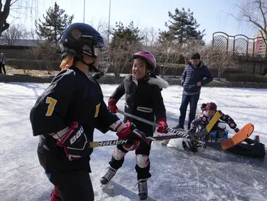 Anak-anak bermain hoki es di kanal beku saat Olimpiade Musim Dingin 2022 hampir berakhir di Beijing pada Sabtu, 19 Februari 2022. (AP Photo/Ng Han Guan)
