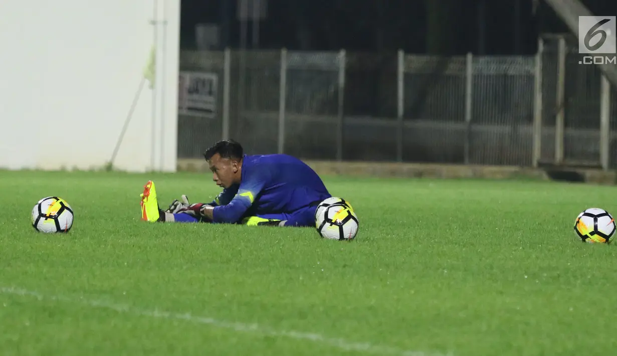 Penjaga gawang Timnas Indonesia U-23, Awan Setho R melakukan peregangan saat latihan di Lapangan B Kompleks GBK, Jakarta, Rabu (30/5). Timnas Indonesia U-23 akan melakoni uji coba melawan Thailand U-23, 31 Mei dan 3 Juni. (Liputan6.com/Helmi Fithriansyah)
