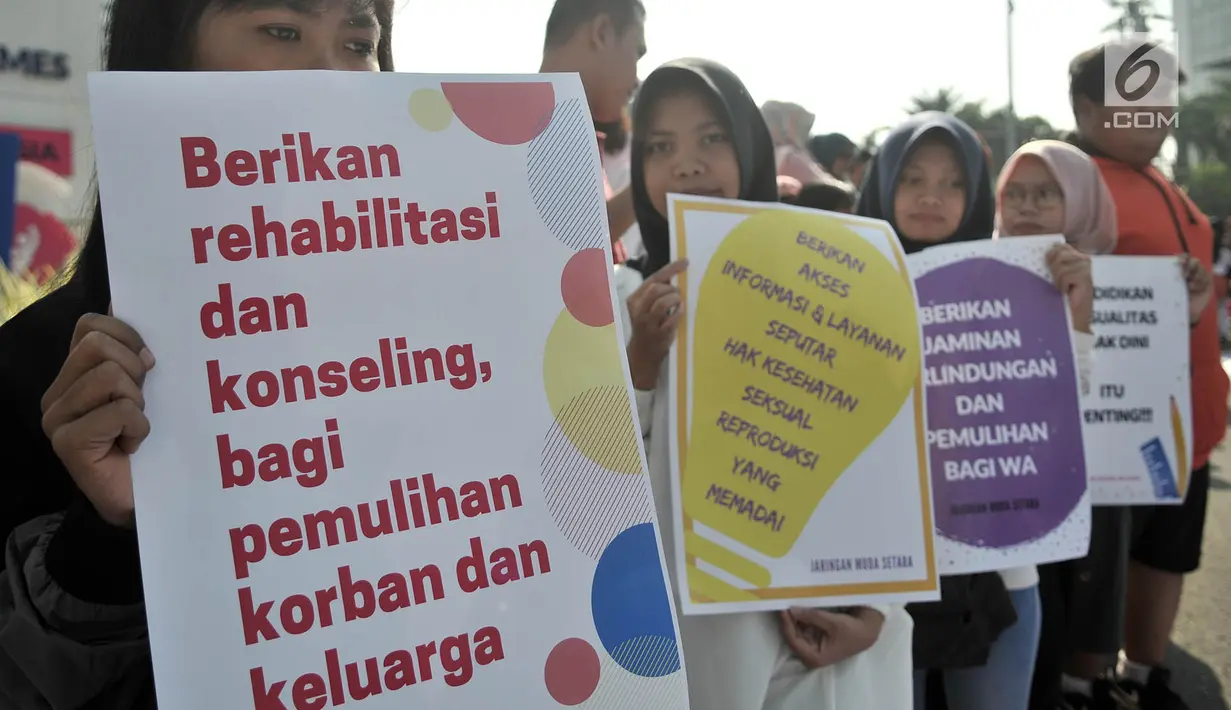 Massa yang tergabung dalam Jaringan Muda Setara menunjukkan poster saat aksi menuntut keadilan untuk WA korban pemerkosaan di kawasan Bundaran HI, Jakarta, Minggu (5/8). (Merdeka.com/Iqbal S. Nugroho)