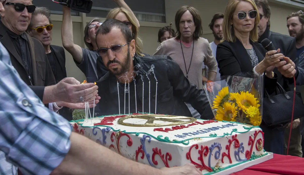 Drummer The Beatles, Ringo Starr meniup lilin saat perayaan ulang tahunnya yang ke-75 di Los Angeles, California, Selasa (7/7/2015). Acara perayaan ulang tahun tersebut bertema Peace & Love. (REUTERS/Mario Anzuoni)