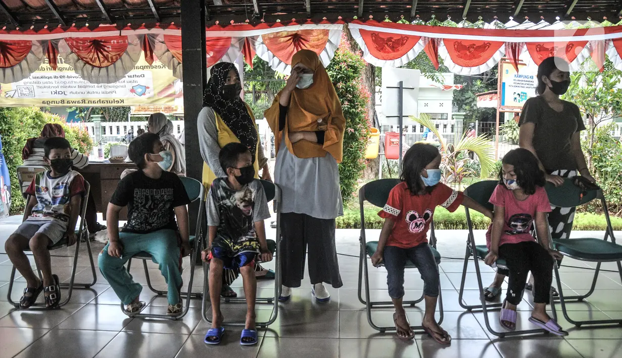 Orangtua mendampingi anaknya mengikuti vaksin Difteri Tetanus (DT) di RPTRA Citra Permata, Jakarta, Selasa (28/9/2021). Kegiatan rutin tahunan tersebut dalam rangka program Bulan Imunisasi Anak Sekolah (BIAS). (merdeka.com/Iqbal S Nugroho)