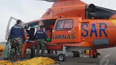 Penyelam TNI-AL memasukan perlengkapan untuk mengangkat ekor AirAsia ke dalam helikopter di Lanud Iskandar, Pangkalan Bun, Kalteng, Sabtu (10/1/2015).  (Liputan6.com/Andrian M Tunay)