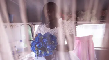 Memori berpose untuk sebuah potret setelah mendapatkan gaun pengantin yang pas di toko penyewaan pengantin di luar Pengadilan Magistrates di Harare, Zimbabwe pada 25 Agustus 2023. (JOHN WESSELS/AFP)