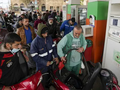 Pengemudi motor menunggu untuk membeli bahan bakar di pompa bensin di pinggiran Beirut, Senin (7/3/2022). Kenaikan harga minyak di seluruh dunia akibat dari invasi Rusia ke Ukraina menyebabkan antrean panjang kendaraan di pompa bensin selama krisis ekonomi terburuk Lebanon. (AP Photo/Hassan Ammar)