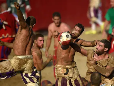 Pemain berebut bola saat pertandingan Calcio Storico Fiorentino di Piazza Santa Croce di Florence, Italia (24/6). Calcio Storico secara harafiah berarti “sepak bola kuno”. Permainan ini berasal dari abad 15. (AFP Photo/Filippo Monteforte)