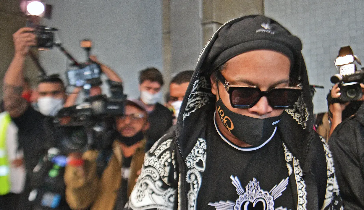 Mantan pemain timnas Brasil, Ronaldinho tiba di bandara El Galeao di Rio de Janeiro, setelah menjalani tahanan rumah di Paraguay, Selasa (25/8/2020). Ronaldinho menghirup udara bebas setelah lima bulan menjadi tahanan rumah karena memasuki Paraguay dengan paspor palsu. (Carl DE SOUZA/AFP)